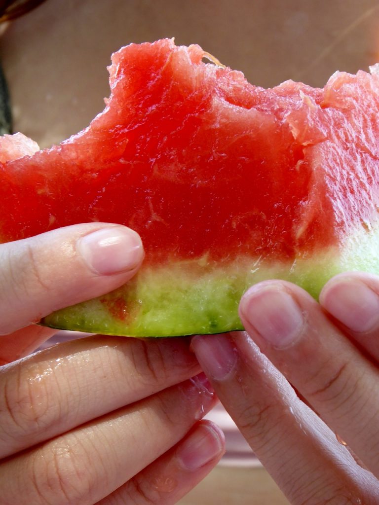 watermelon in a hand with healthy nails