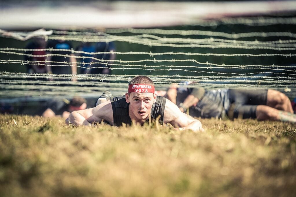 man on ground during spartan race