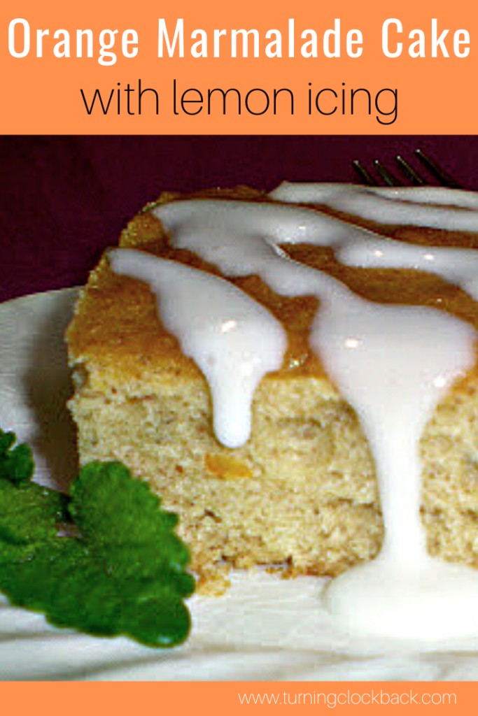 Orange Marmalade Cake with lemon icing on a white plate with fresh mint