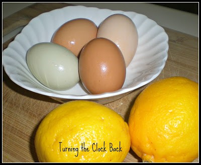 fresh lemons and eggs in a white bowl on a cutting board