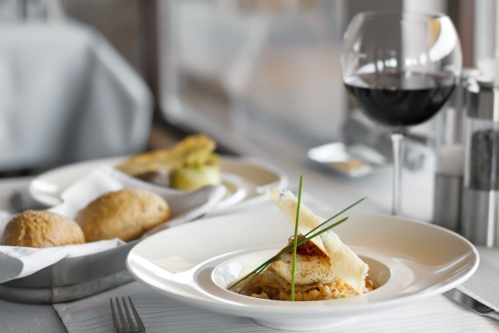 upscale restaurant table with food, dishes and wine