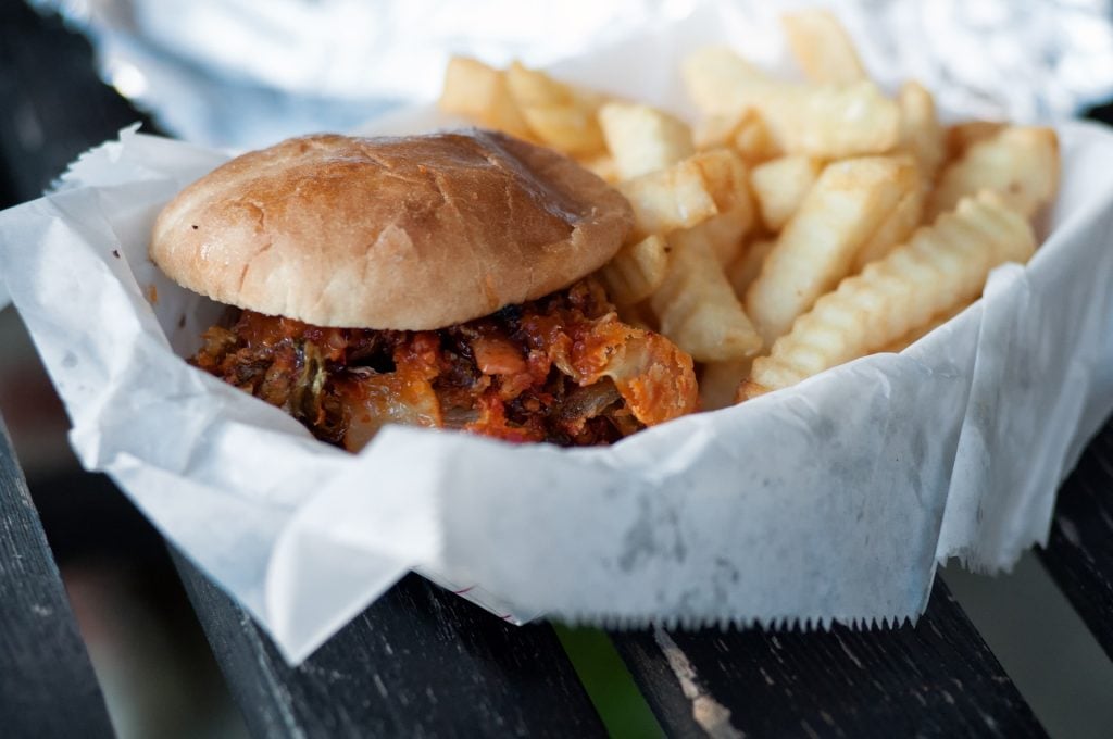 hamburger and fries in a basket with disposable paper 