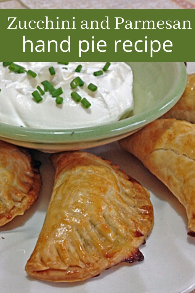 Zucchini and Parmesan hand pies on a plate with sour cream dip