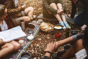 adults sitting outside camping