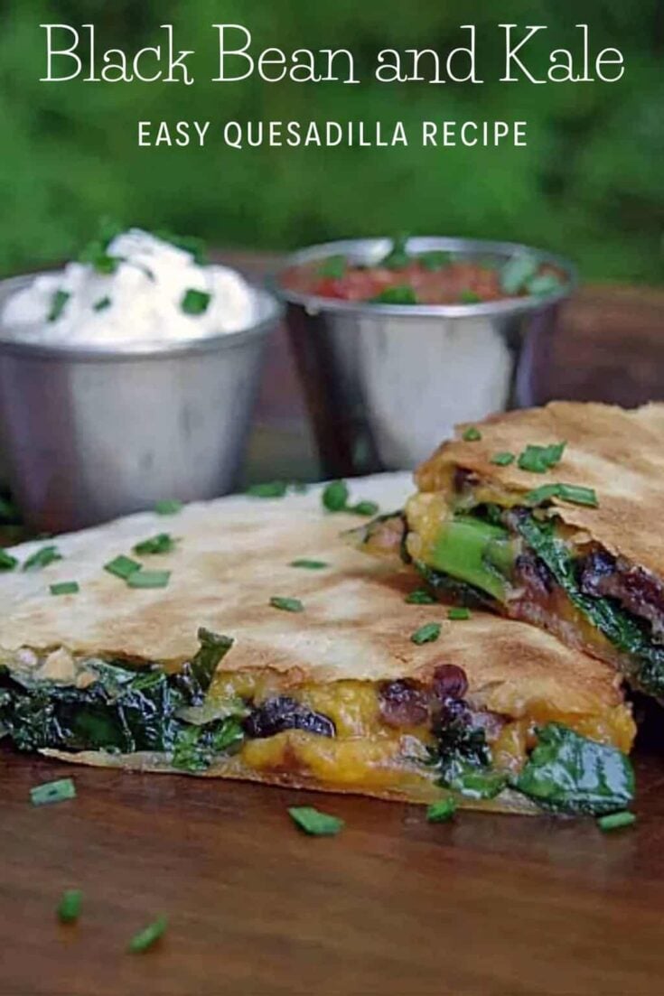 Kale and black bean quesadillas on a plate with containers of sour cream and salsa