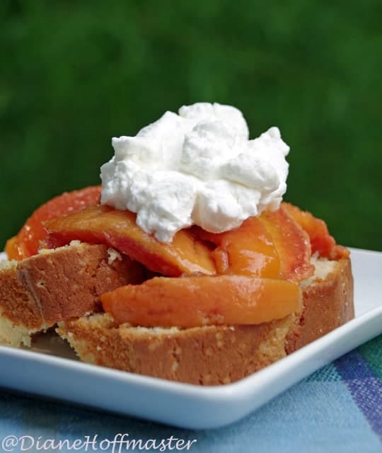 cake topped with fresh peaches and whipped cream