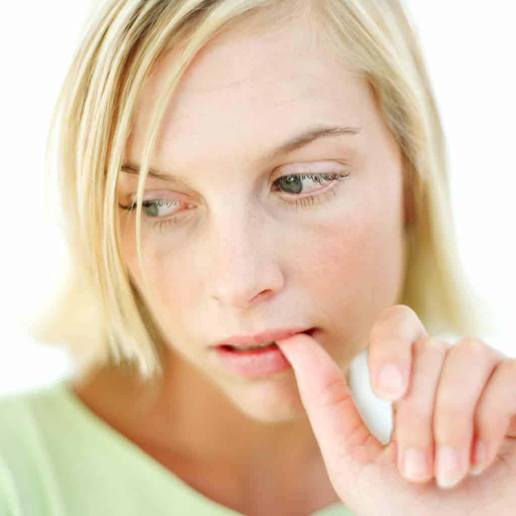 Young Woman Biting Her Finger Nail
