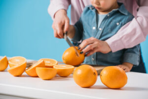 adult and child cutting oranges
