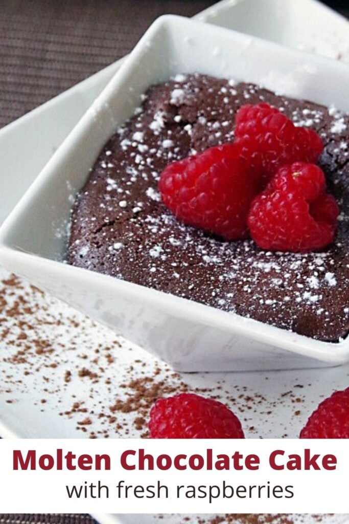 molten chocolate cake in a white bowl with fresh raspberries on top