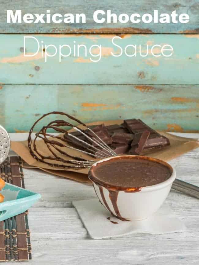 Traditional churros with hot chocolate dipping sauce on wooden counter top.