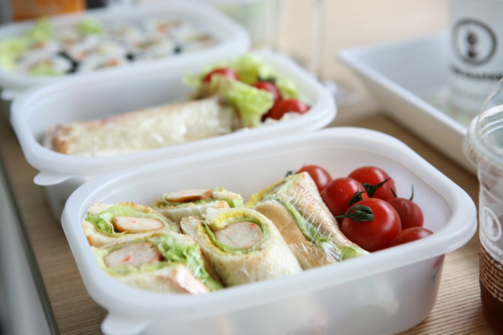 reusable containers with sandwiches and cherry tomatoes in them