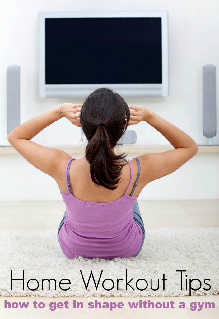 woman working out at home doing situps in front of the tv