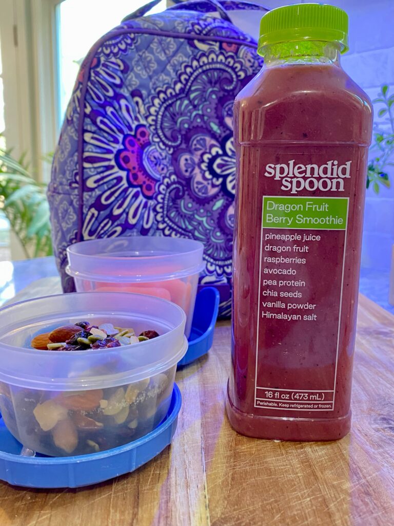 splendid spoon smoothie and containers of healthy food in front of cloth lunchbox