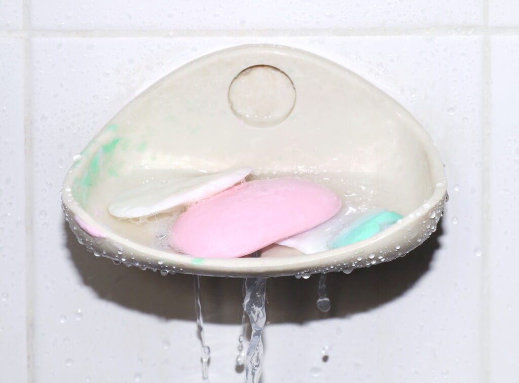 soap scraps on dish at shower wall,