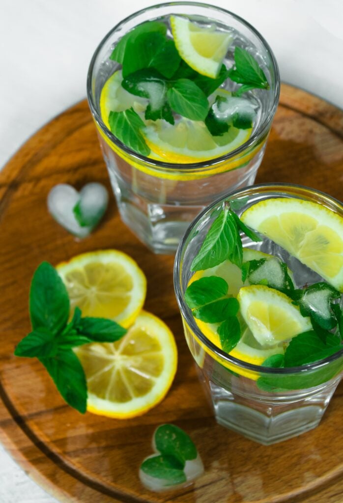 glasses of lemon balm and lemons in water