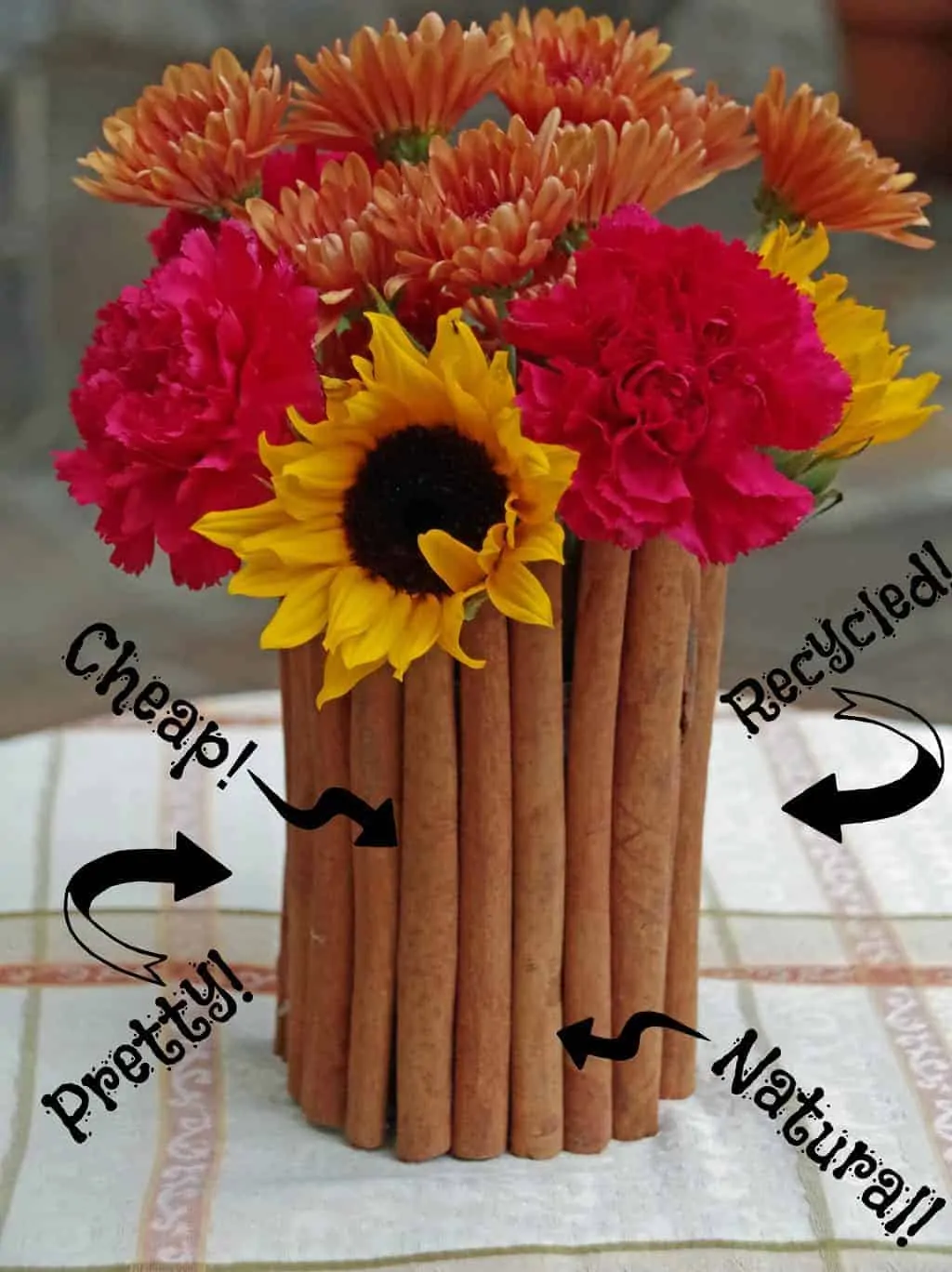 upcycled tin can covered in cinnamon sticks with flowers in it