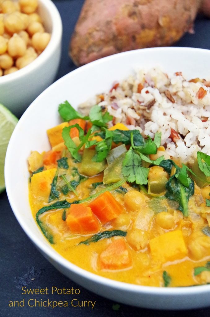 Sweet Potato and Chickpea Curry Over Rice with Lime in a white bowl