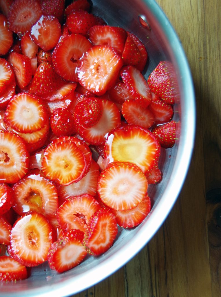 Sliced strawberries in pan with honey