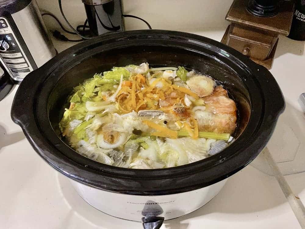 homemade stock in crockpot using vegetable scraps and chicken bones