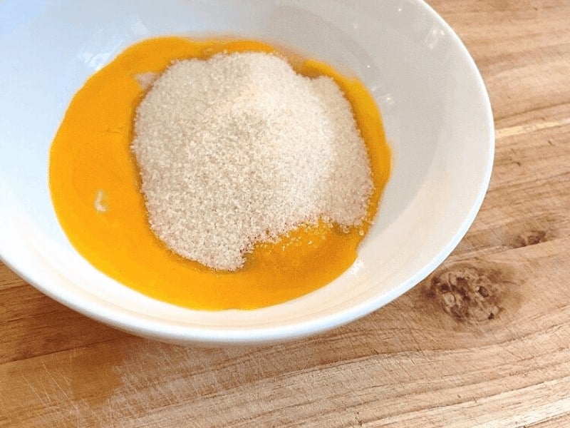 Egg yolks and sugar in bowl