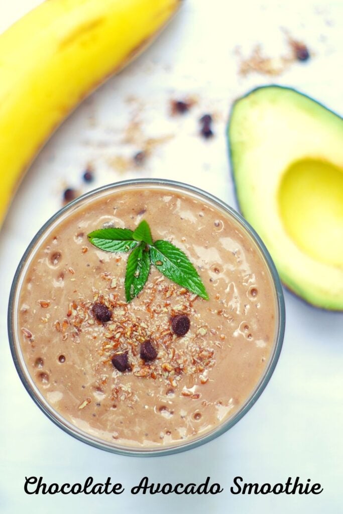 chocolate avocado smoothie in a glass with banana and avocado next to it