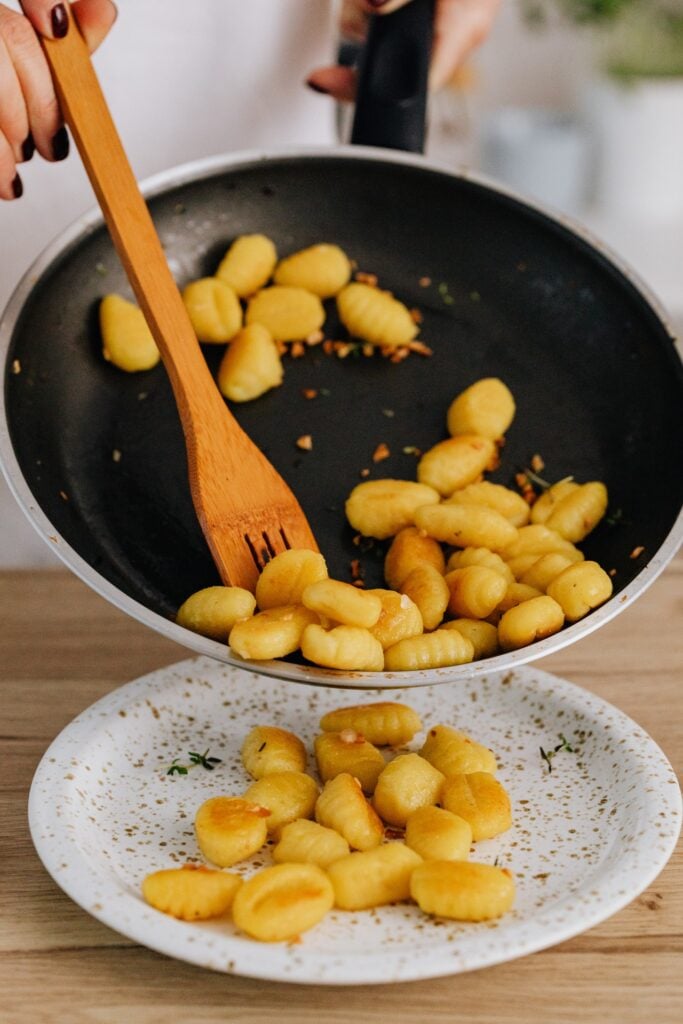 gnocci in nonstick cookware sliding onto plate