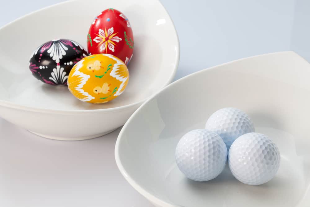 Two white ceramics bowls,golf balls and easter eggs