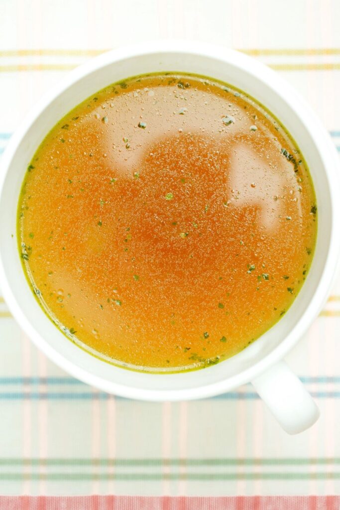 mug of homemade turkey broth made from turkey carcass in slow cooker